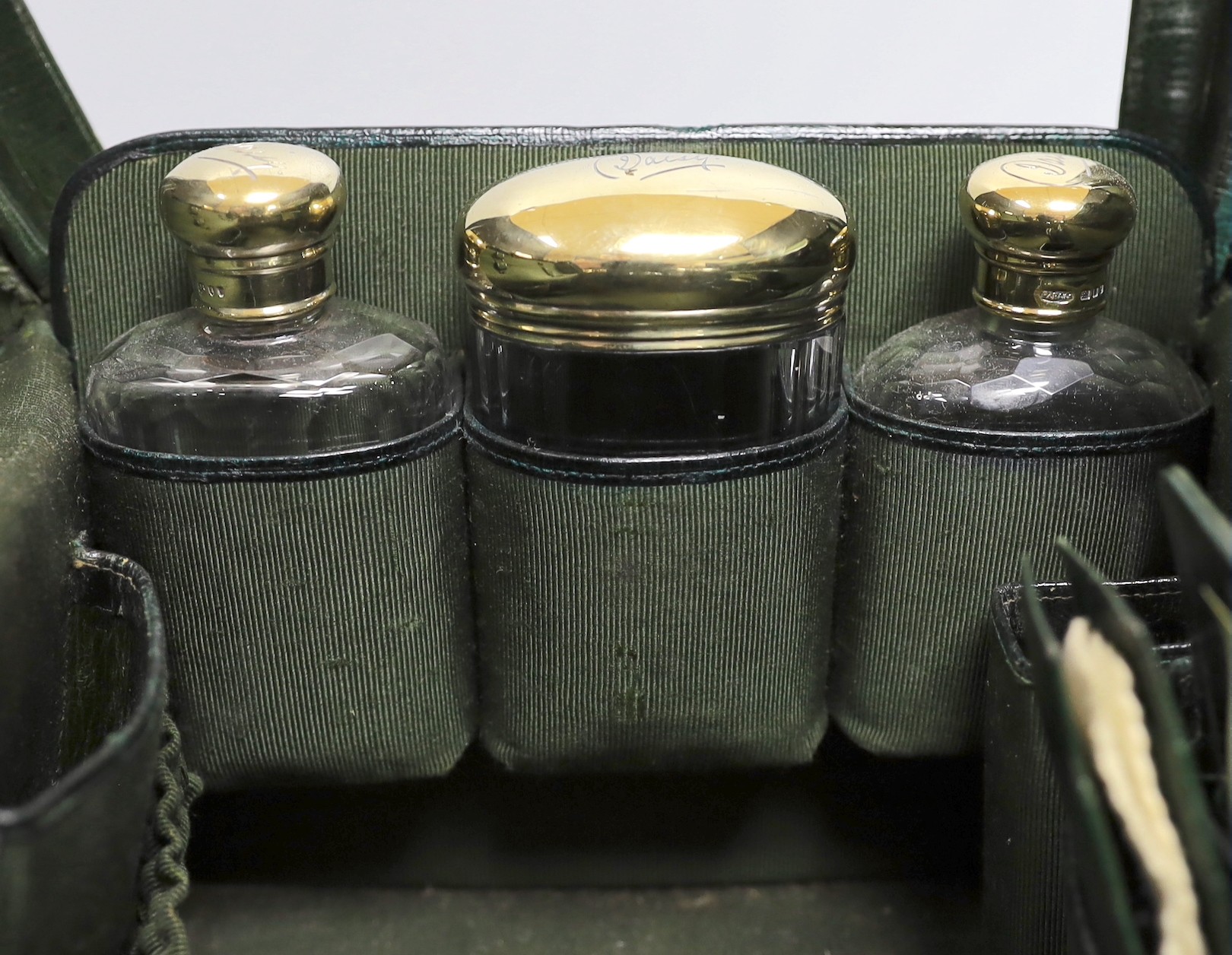 A late Victorian leather Gladstone toilet case, containing eight silver gilt mounted glass toilet jars, all engraved 'Daisy', two makers, London, 1894 & 1898, bag length 33cm.